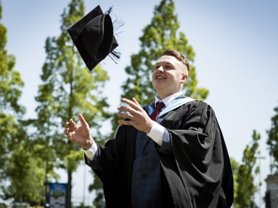 graduate throwing hat in the air